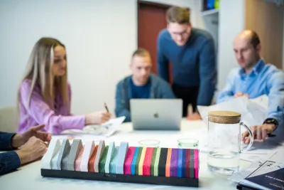 Tím pri stole s farebnými vzorkami akustických materiálov počas konzultácie k certifikácii budovy.
