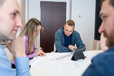 Tím pri stole s výkresmi a tabletom preberá projekt logistického parku DCA P3.