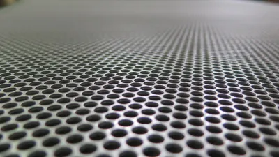 Detail perforovaného kovového panelu použitého na akustickú úpravu, projekt Nahrávacie štúdio.